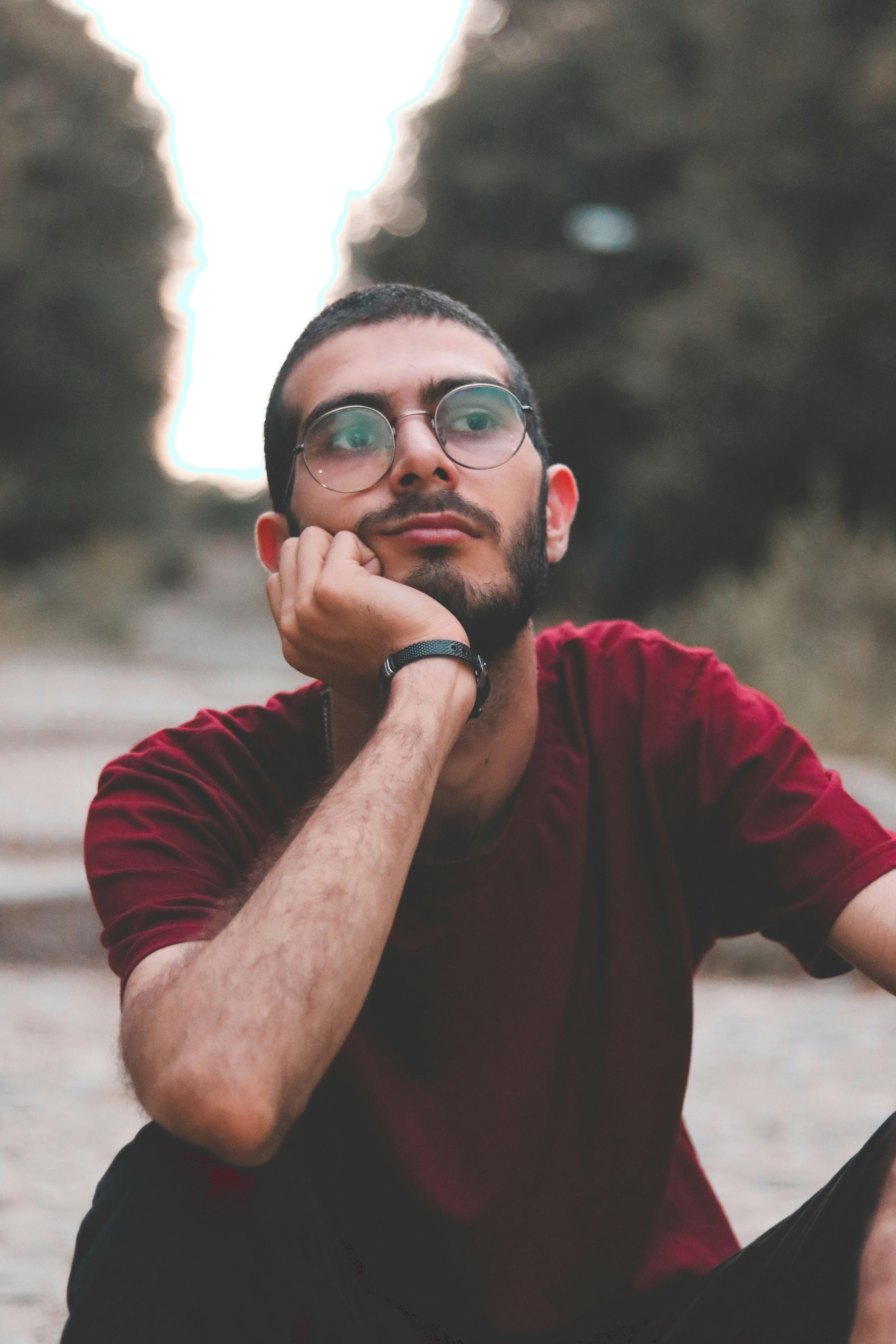 man in red crew neck t-shirt wearing black framed eyeglasses